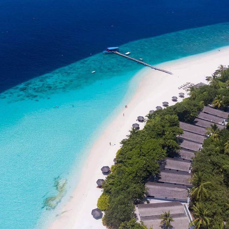 High angle view of white sand beach with resorts at Maldives