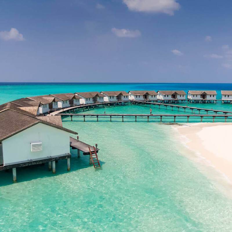 View of water villas with white sand beach at Maldives