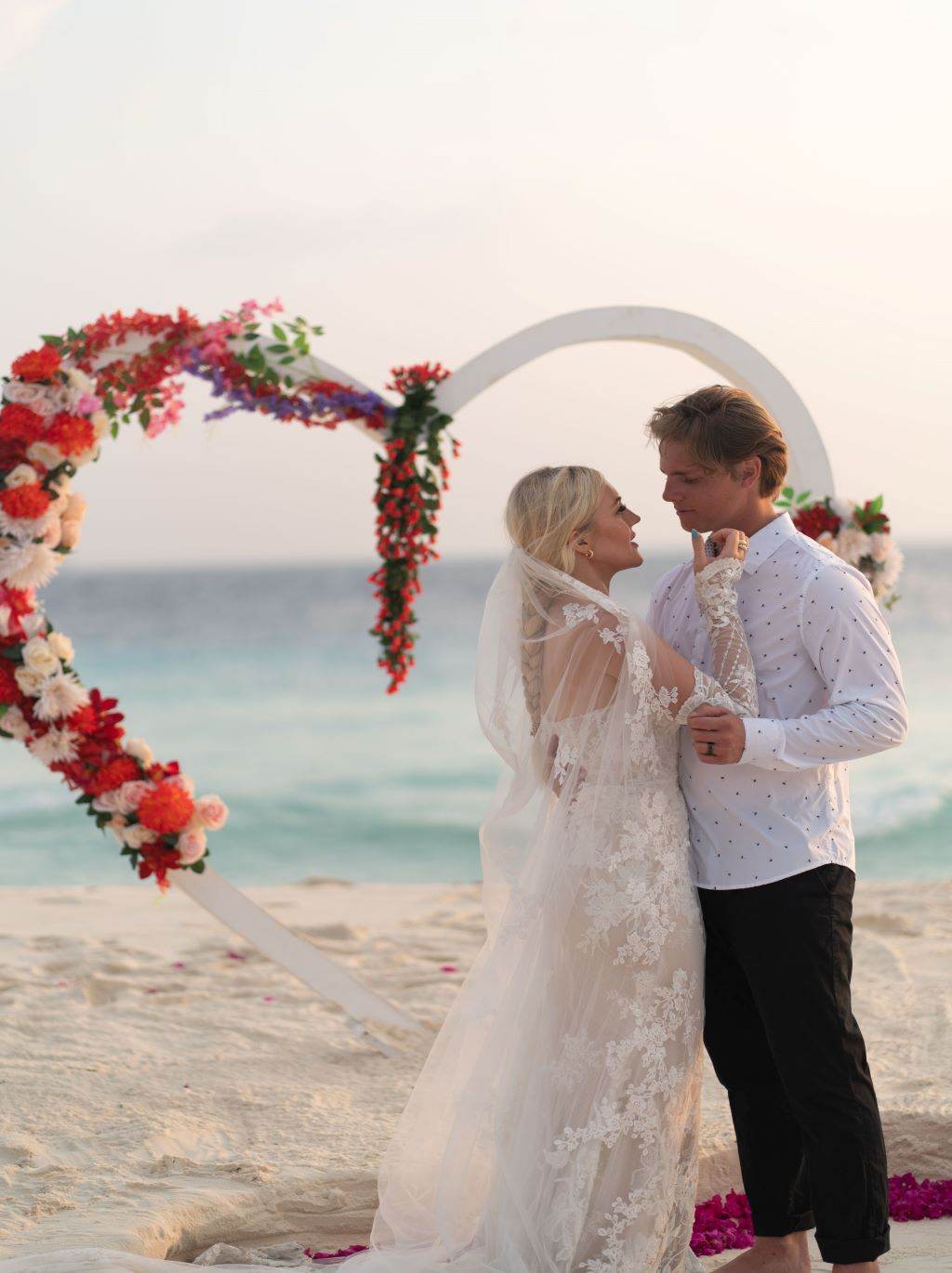 A married couple poses on a Maldives beach 