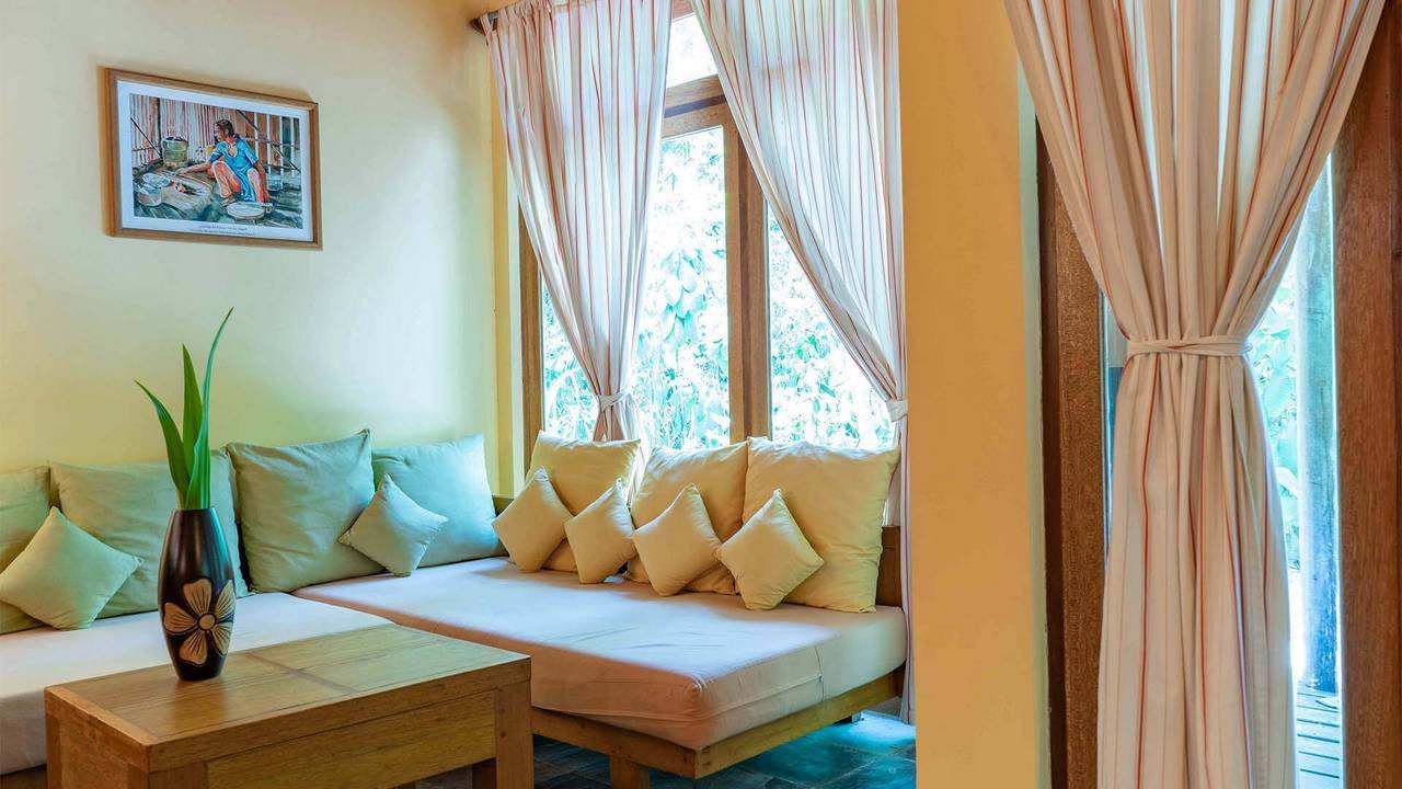 Closeup of a sofa in a lounge at  Reethi Garden Villa, Maldives
