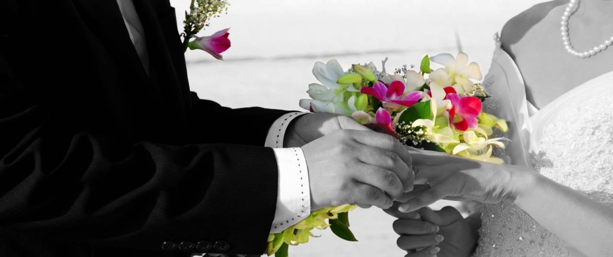 Closeup of bride and groom exchanging rings at Reethi Resort, Maldives