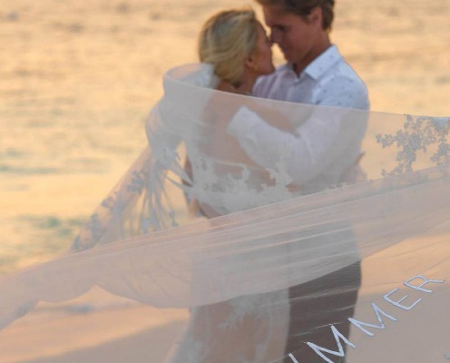 A married couple poses on a Maldives beach.