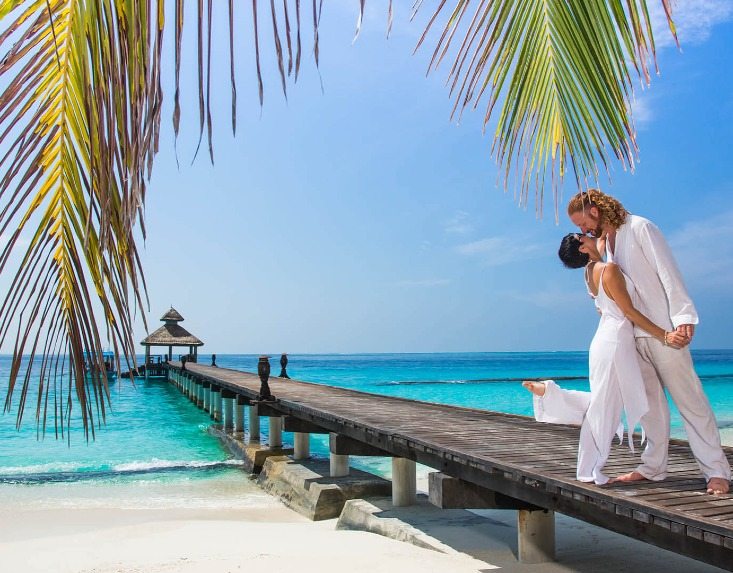 Couples on a wooden path at the Maldives sea